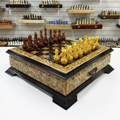 Шахматы из янтаря и бука в ларце с выдвижными ящиками 47 см